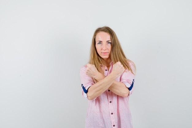 Jonge blonde vrouw in een casual roze shirt