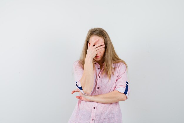 Jonge blonde vrouw in een casual roze shirt