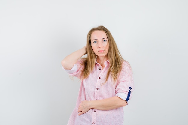 Jonge blonde vrouw in een casual roze shirt