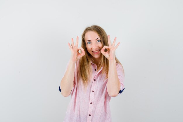 Jonge blonde vrouw in een casual roze shirt