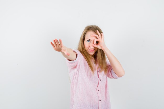 Jonge blonde vrouw in een casual roze shirt