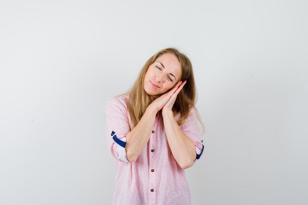 Jonge blonde vrouw in een casual roze shirt