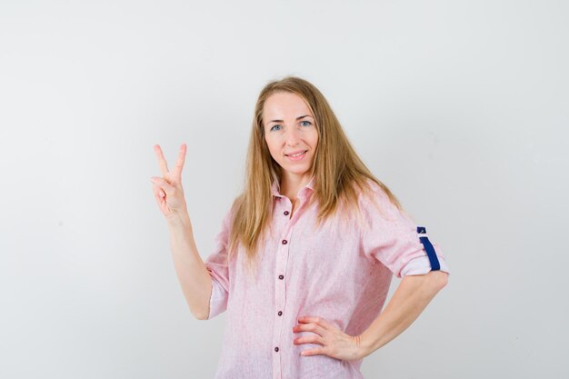 Jonge blonde vrouw in een casual roze shirt