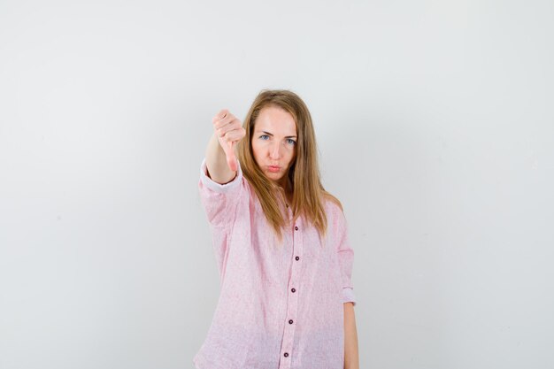 Jonge blonde vrouw in een casual roze shirt