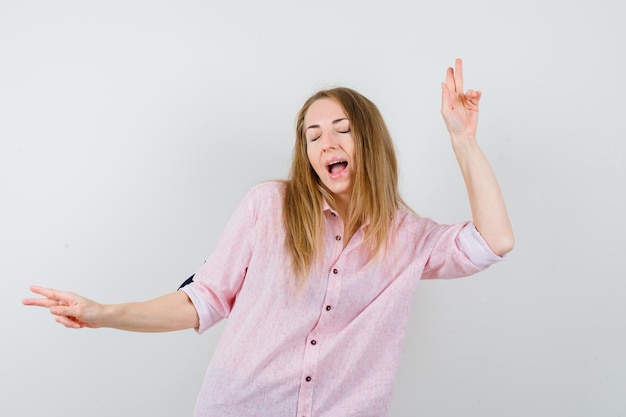 Jonge blonde vrouw in een casual roze shirt