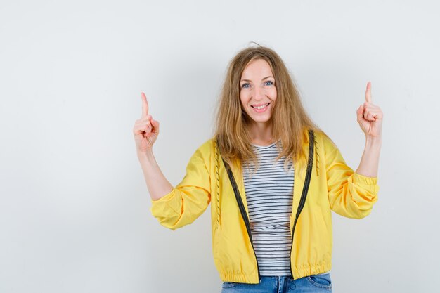 Jonge blonde vrouw in een geel jasje