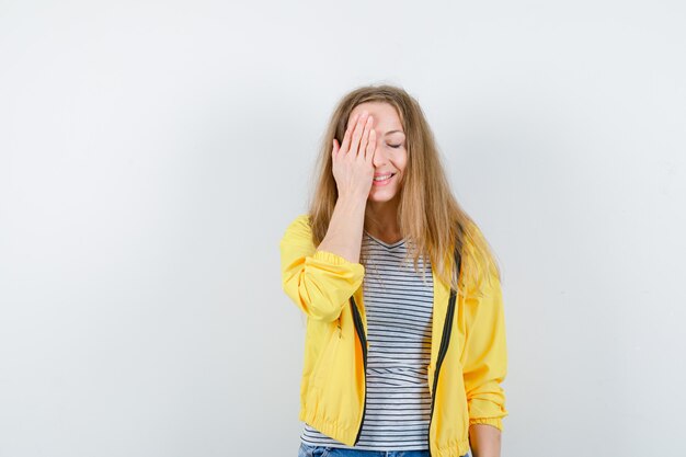 Jonge blonde vrouw in een geel jasje