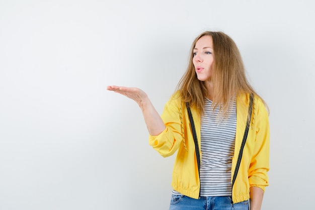 Jonge blonde vrouw in een geel jasje