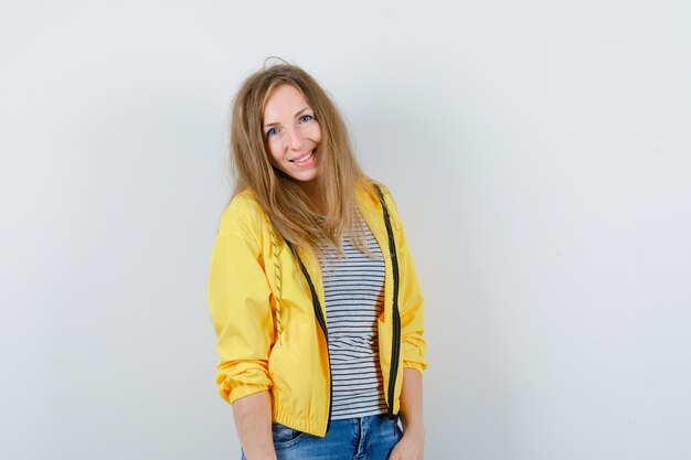 Jonge blonde vrouw in een geel jasje