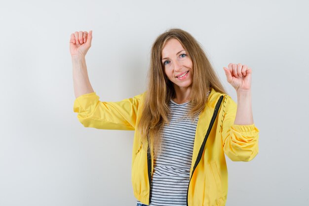 Jonge blonde vrouw in een geel jasje