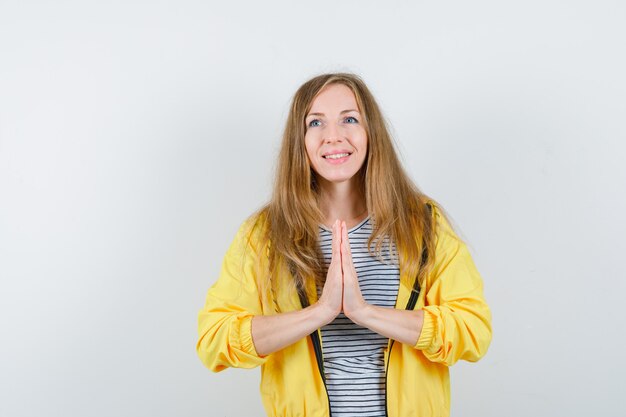 Jonge blonde vrouw in een geel jasje