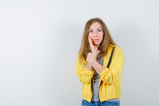 Jonge blonde vrouw in een geel jasje