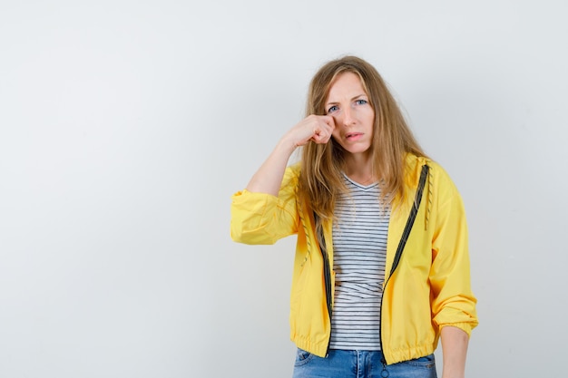 Jonge blonde vrouw in een geel jasje