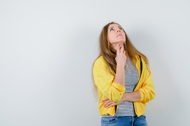 Jonge blonde vrouw in een geel jasje