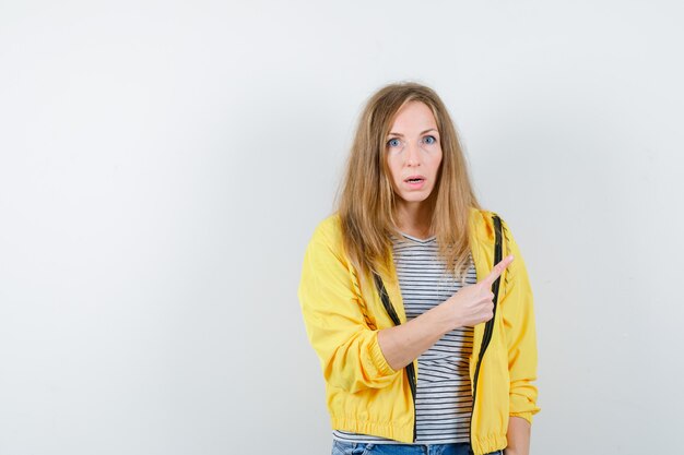 Jonge blonde vrouw in een geel jasje