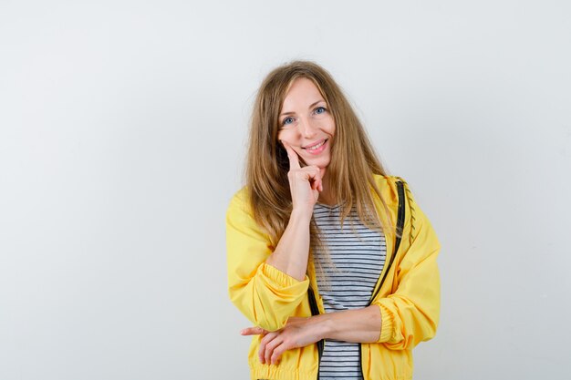 Jonge blonde vrouw in een geel jasje