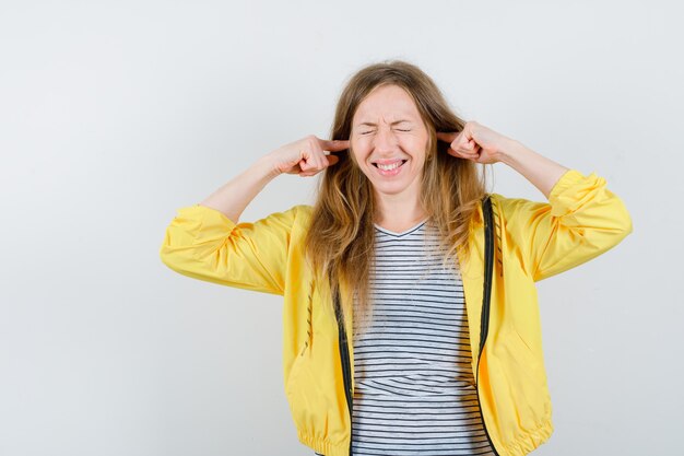 Jonge blonde vrouw in een geel jasje