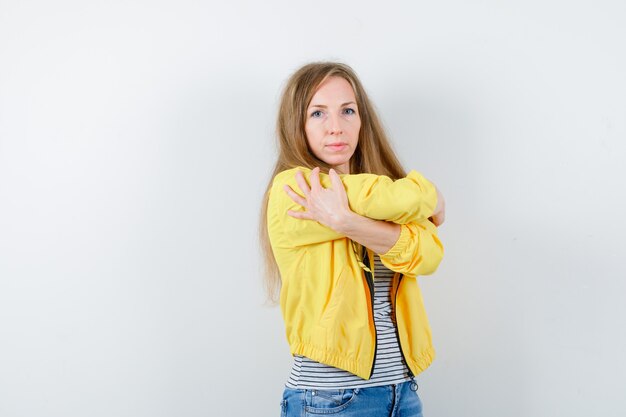 Jonge blonde vrouw in een geel jasje