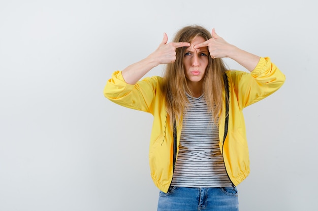 Jonge blonde vrouw in een geel jasje