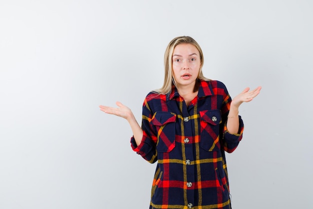 Jonge blonde vrouw in een geruit hemd