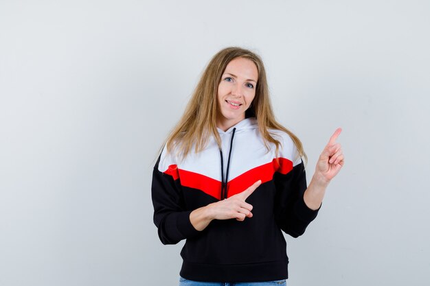Jonge blonde vrouw in een jasje en spijkerbroek