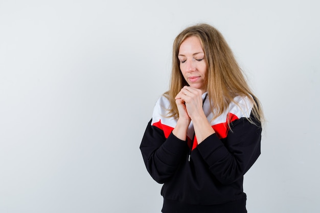 Jonge blonde vrouw in een jasje en spijkerbroek