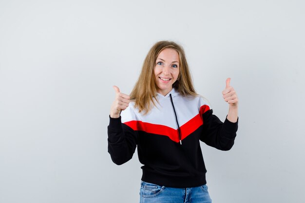 Jonge blonde vrouw in een jasje en spijkerbroek