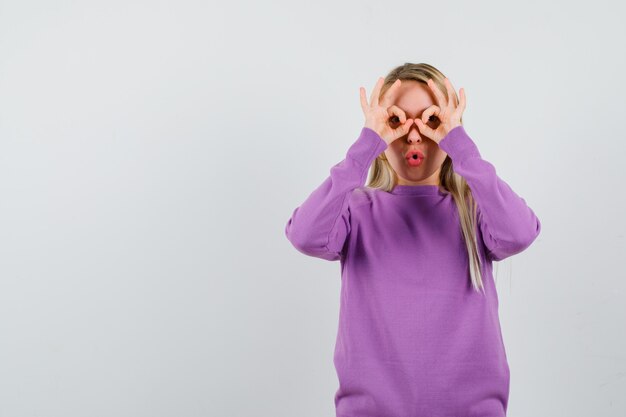 Jonge blonde vrouw in een paarse trui