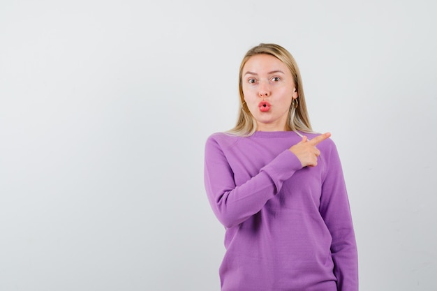 Jonge blonde vrouw in een paarse trui