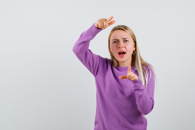 Jonge blonde vrouw in een paarse trui