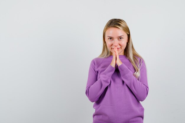 Jonge blonde vrouw in een paarse trui