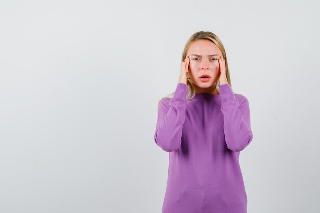 Jonge blonde vrouw in een paarse trui