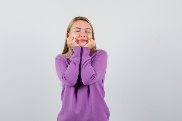 Jonge blonde vrouw in een paarse trui