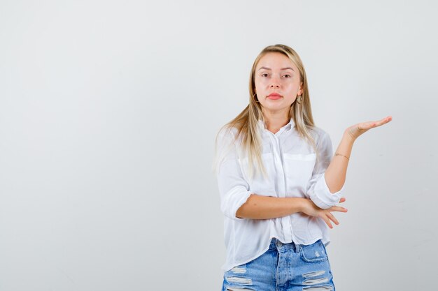 Jonge blonde vrouw in een wit overhemd