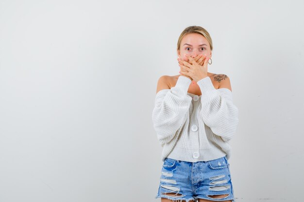 Jonge blonde vrouw in een witte trui