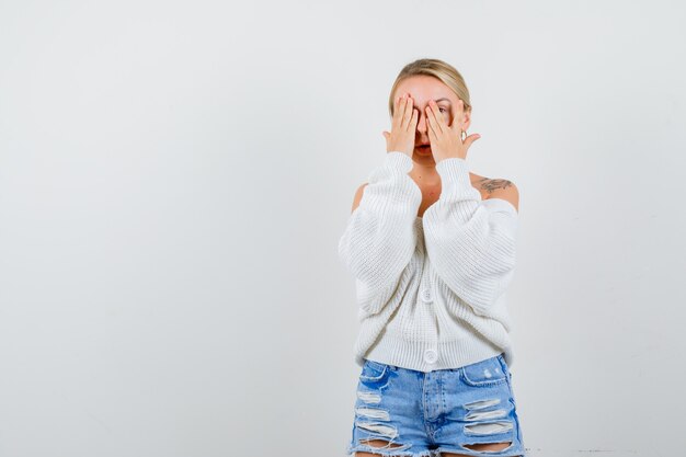 Jonge blonde vrouw in een witte trui