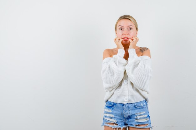 Jonge blonde vrouw in een witte trui