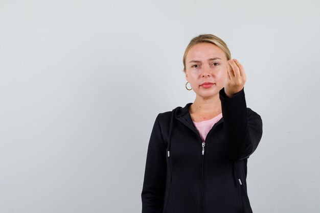 Jonge blonde vrouw in een zwarte jas