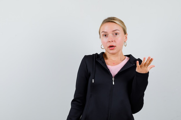 Jonge blonde vrouw in een zwarte jas