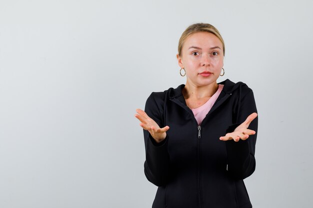 Jonge blonde vrouw in een zwarte jas