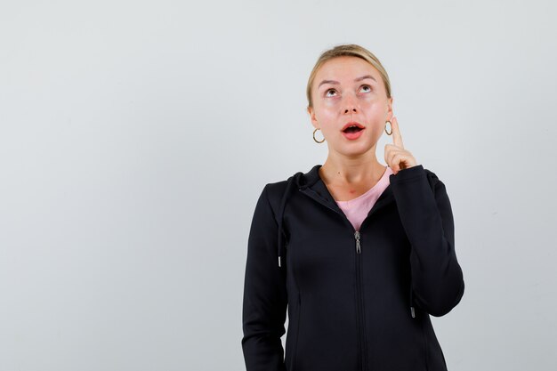 Jonge blonde vrouw in een zwarte jas