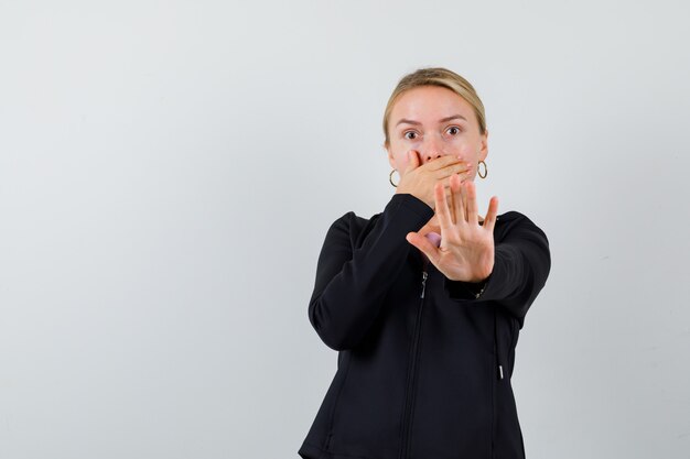 Jonge blonde vrouw in een zwarte jas