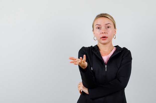 Jonge blonde vrouw in een zwarte jas