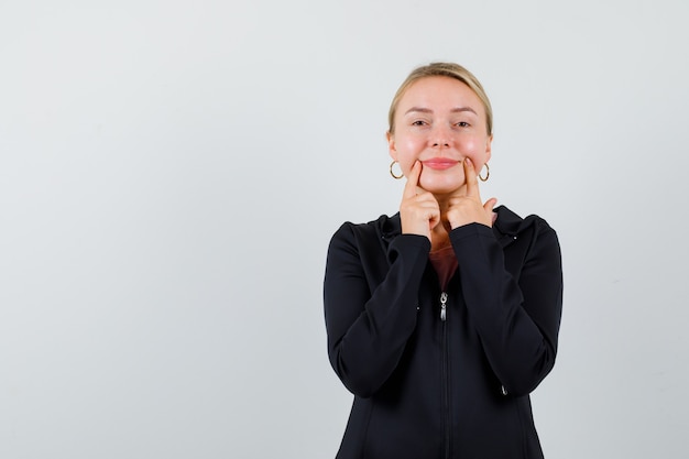 Jonge blonde vrouw in een zwarte jas