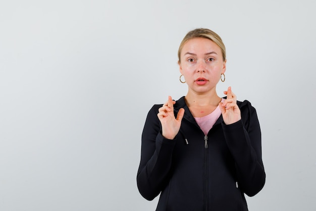 Jonge blonde vrouw in een zwarte jas