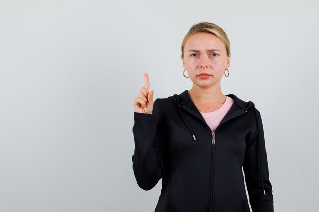 Jonge blonde vrouw in een zwarte jas