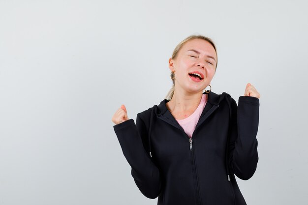 Jonge blonde vrouw in een zwarte jas