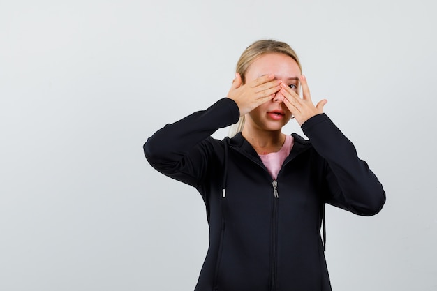 Jonge blonde vrouw in een zwarte jas