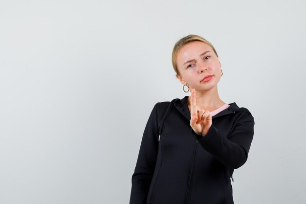 Jonge blonde vrouw in een zwarte jas