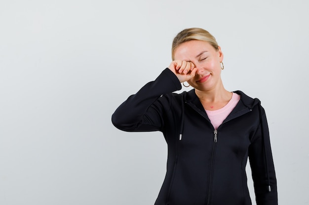 Jonge blonde vrouw in een zwarte jas